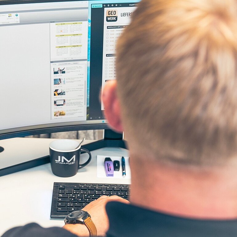 Mitarbeiter am PC verwendet den Baustellen-Manager in BUSINESS.