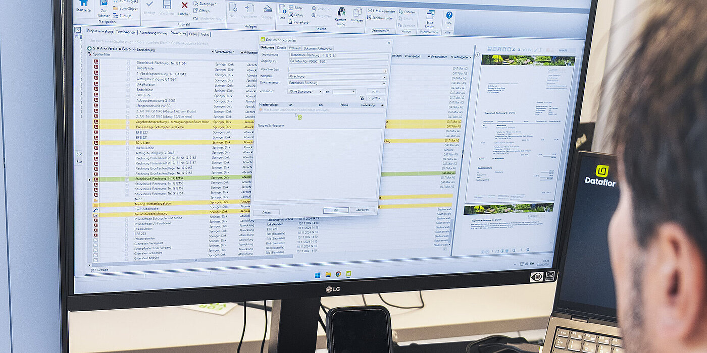 Mann am PC nutzt die Bauakte von BUSINESS