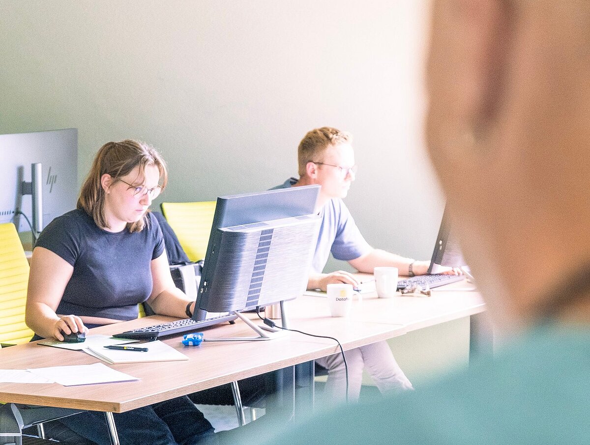 Teilnehmende arbeiten während einer Software-Schulung am Computer